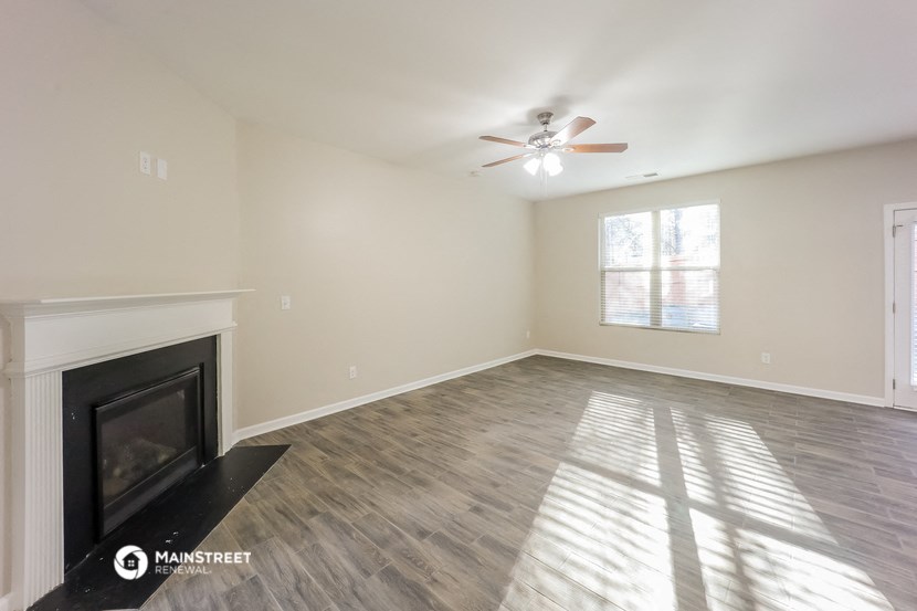 a living room with a fireplace and a ceiling fan