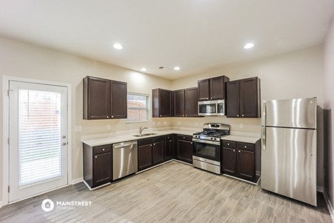 a kitchen with stainless steel appliances and dark cabinets