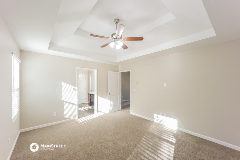 an empty living room with a ceiling fan