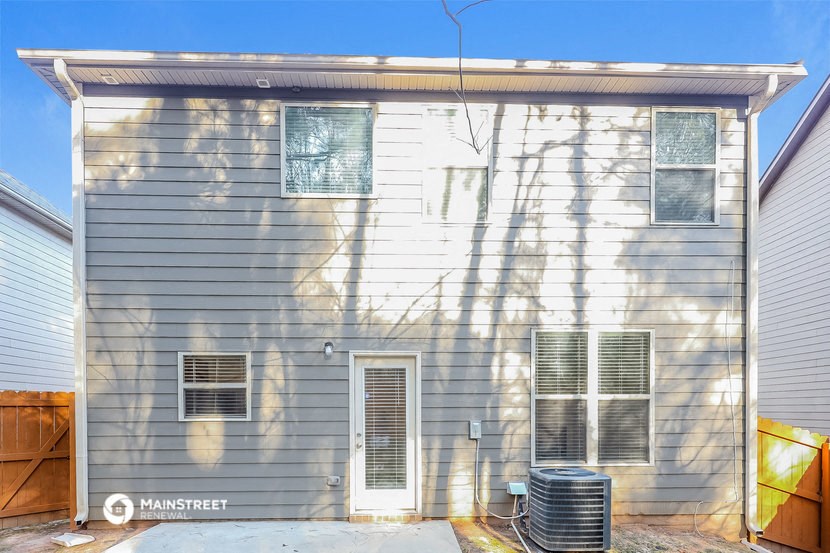 the side of a house with a yard and a radiator on it