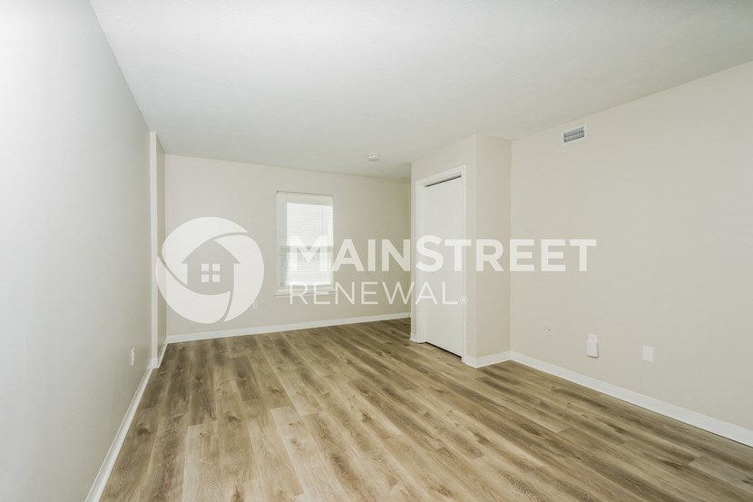 a renovated living room with hardwood floors and white walls