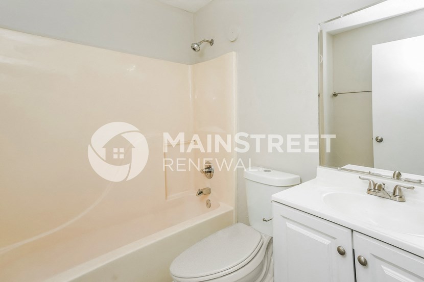 a white bathroom with a toilet and a sink