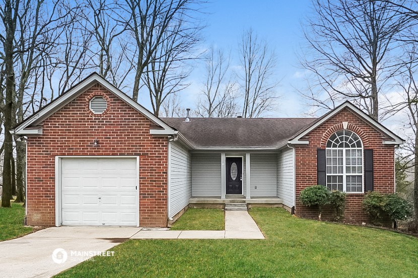 the front of a brick house with a white garage door