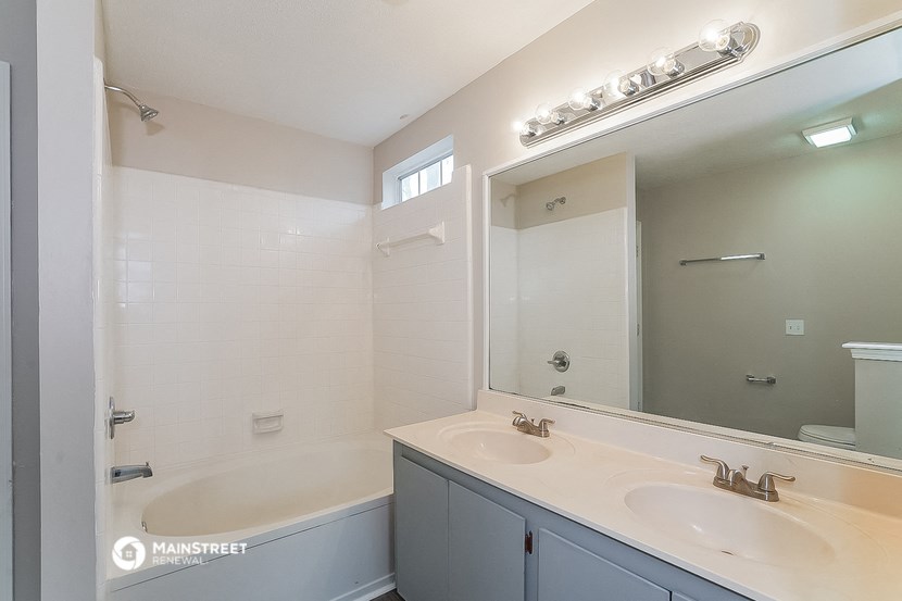 a bathroom with two sinks and a shower and a mirror