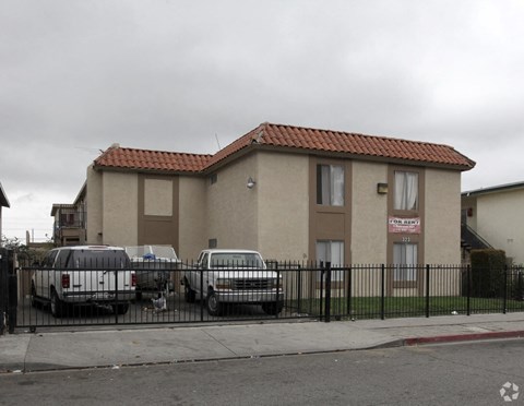 a house with cars parked in front of a fence