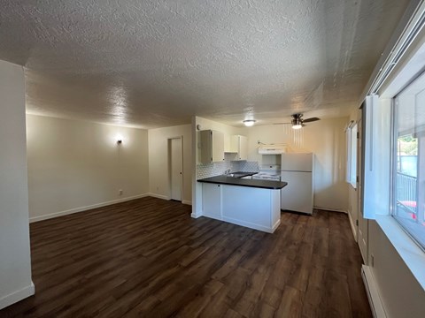 A kitchen with white cabinets and a black countertop is shown.