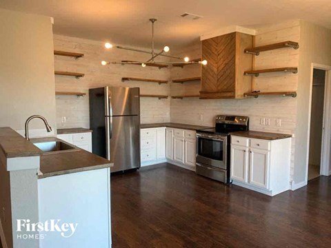 A kitchen with wooden cabinets and a stainless steel refrigerator.