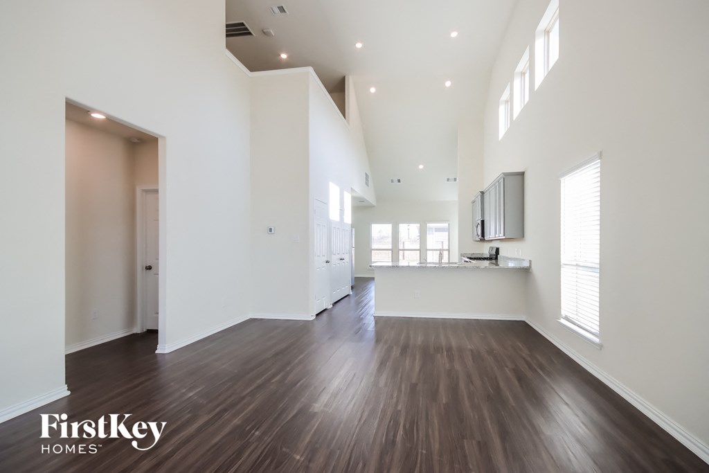 A spacious room with wooden floors and white walls.