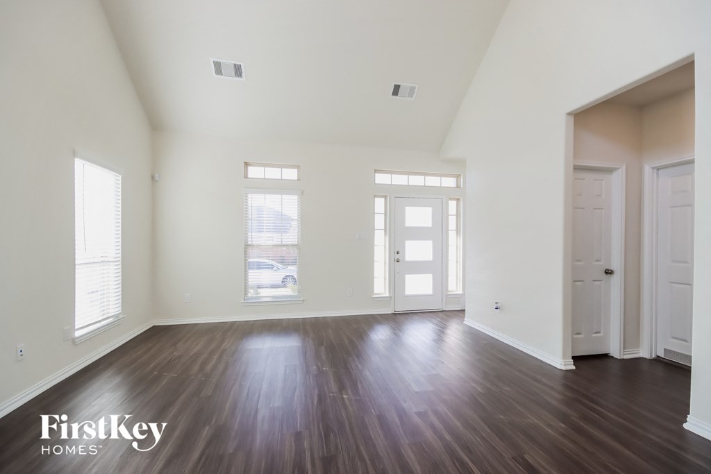 A spacious room with wooden floors and white walls.