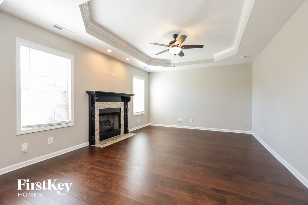 a living room with a fireplace and a ceiling fan