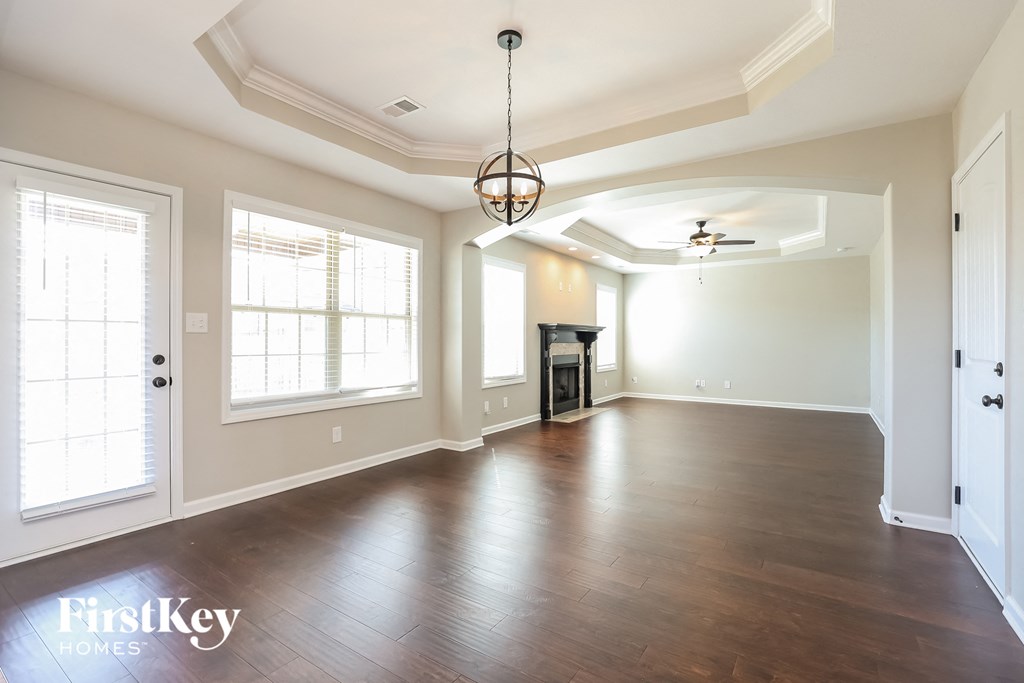 an empty living room with wood floors and a ceiling fan