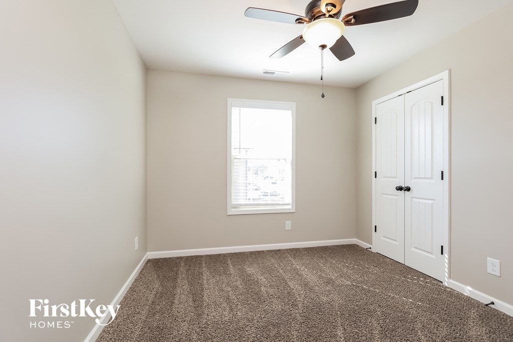 a bedroom with a ceiling fan and a white door