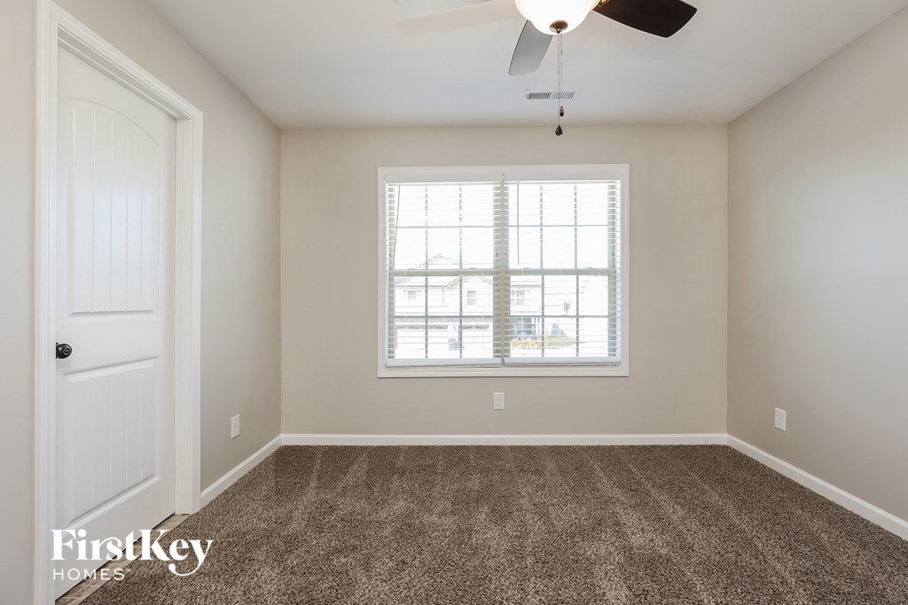 a empty living room with carpet and a window