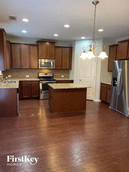 a large kitchen with wooden floors and stainless steel appliances
