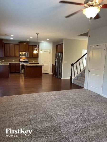 a living room with a kitchen and a staircase
