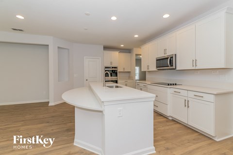 A kitchen with white cabinets and a white island.