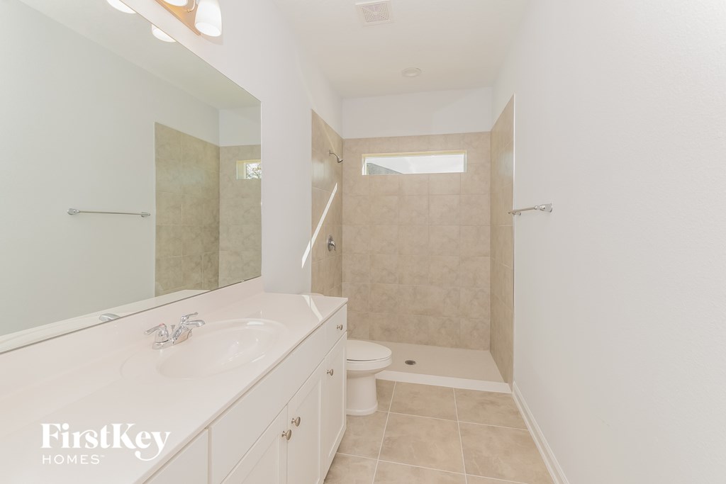 A bathroom with a toilet, sink, and shower.