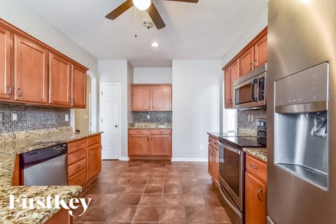 A kitchen with brown cabinets and a tile floor.