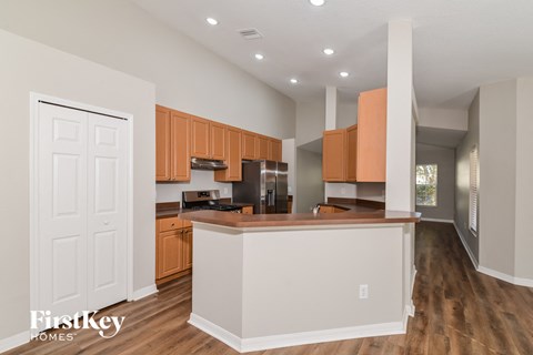 a kitchen with a white island and wooden cabinets