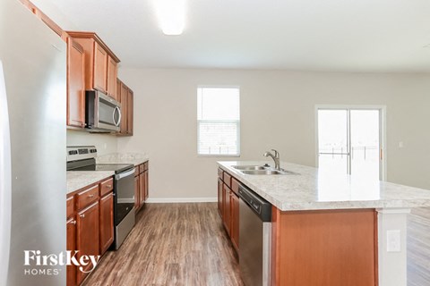 A kitchen with wooden cabinets and a marble countertop.