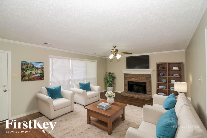 A living room with a fireplace and a painting on the wall.