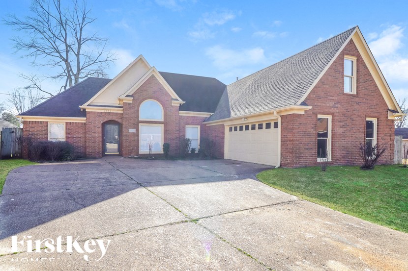 a brick house with a driveway and a white garage door