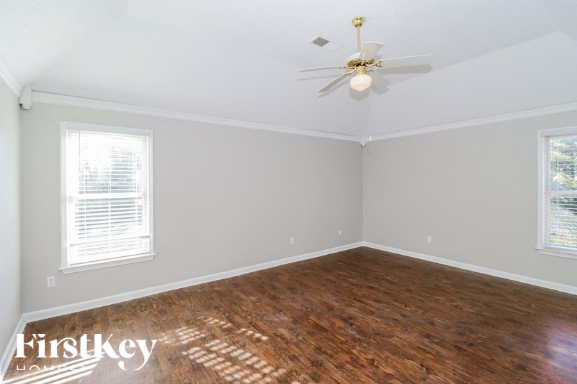 a bedroom with wood flooring and a ceiling fan