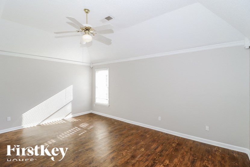 a bedroom with hardwood floors and a ceiling fan