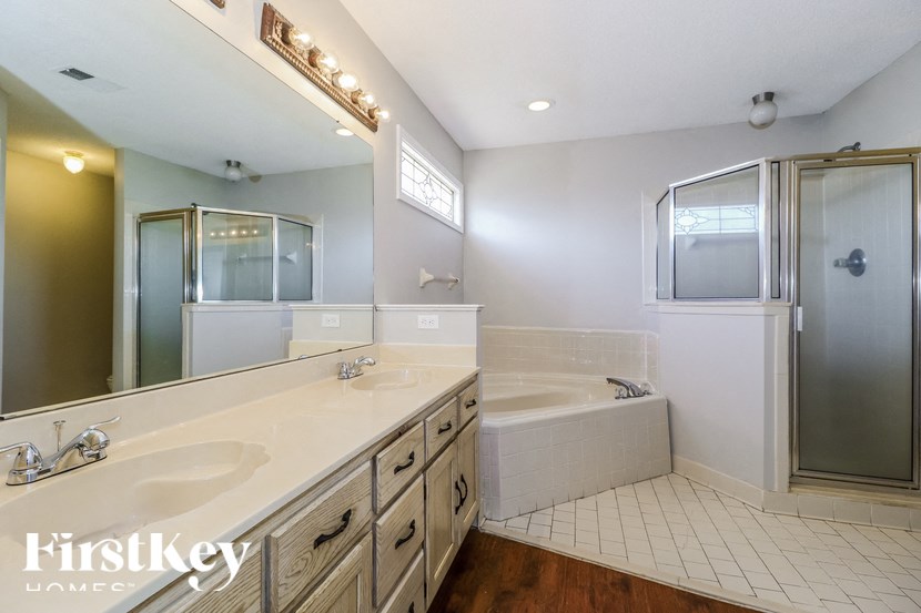 a white bathroom with two sinks and a tub and a shower