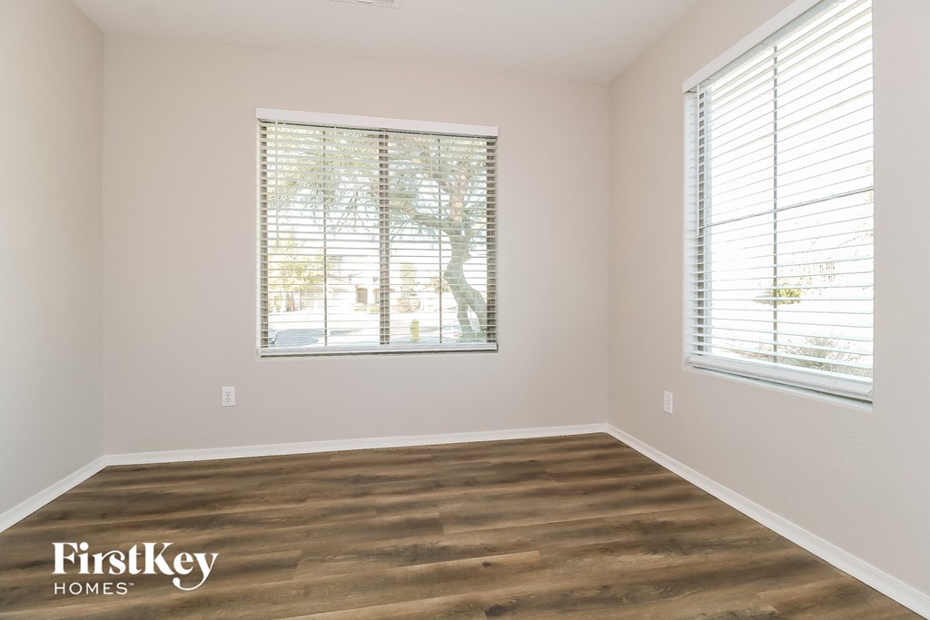 a living room with wood floors and two windows