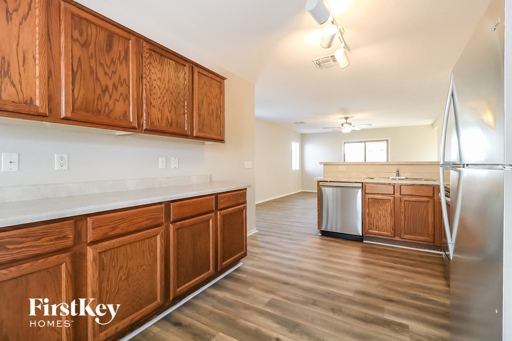 a kitchen with wooden cabinets and a stainless steel refrigerator