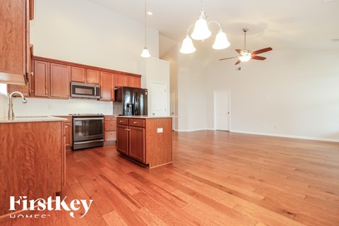 A kitchen with wooden cabinets and a microwave.