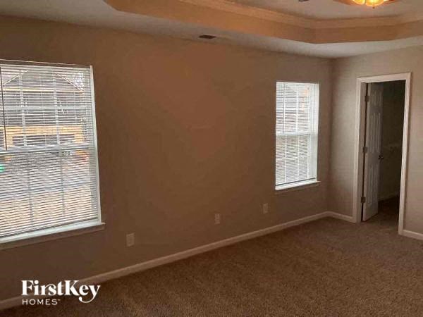 an empty living room with two windows and a door
