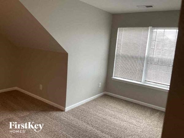 an empty room with a window and a carpeted floor