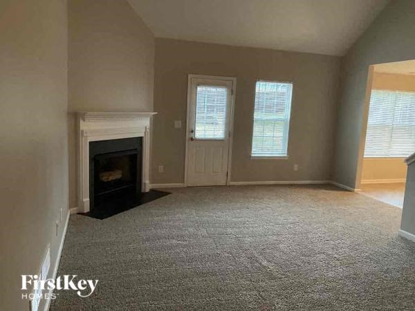 a large empty living room with a fireplace