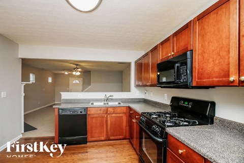 A kitchen with wooden cabinets and black appliances.