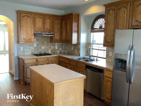 a kitchen with wooden cabinets and a refrigerator and a sink