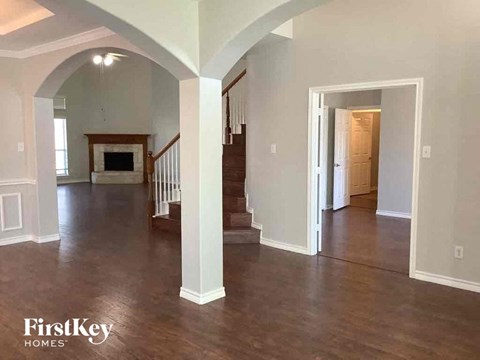 an empty living room with a hard wood floor and a staircase