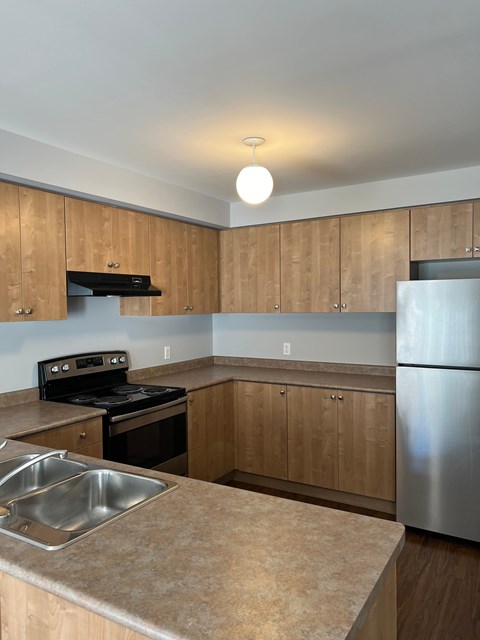 a kitchen with stainless steel appliances and wooden cabinets