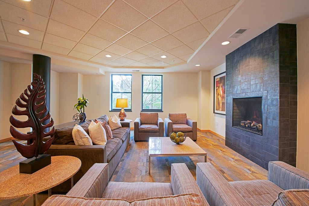 A living room with a sofa, chairs, a fireplace, and a large sculpture.