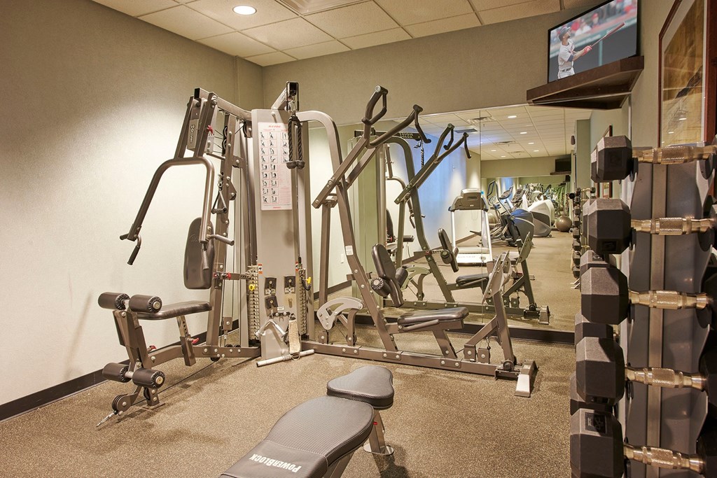 A gym with a variety of equipment including a flat screen TV.
