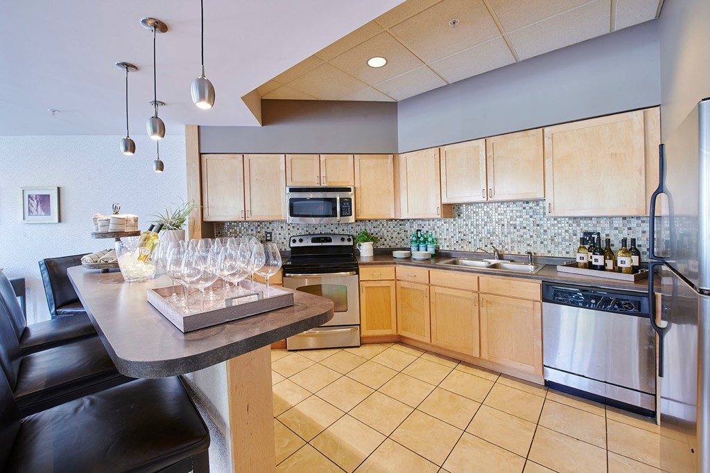 A kitchen with a bar and a microwave above the stove.