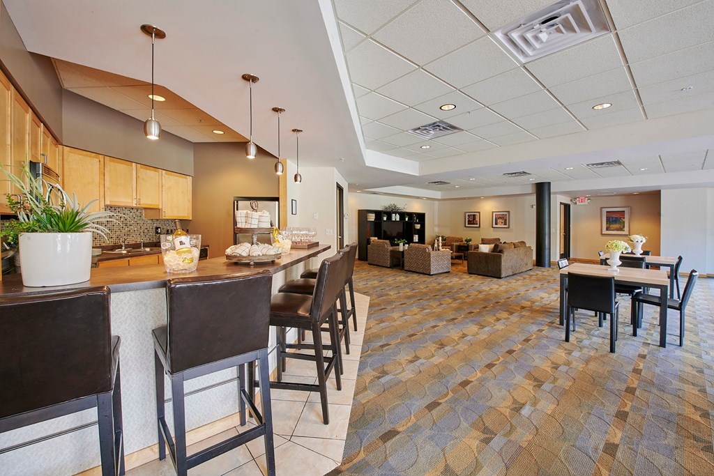 A dining area with a bar, tables, and chairs.
