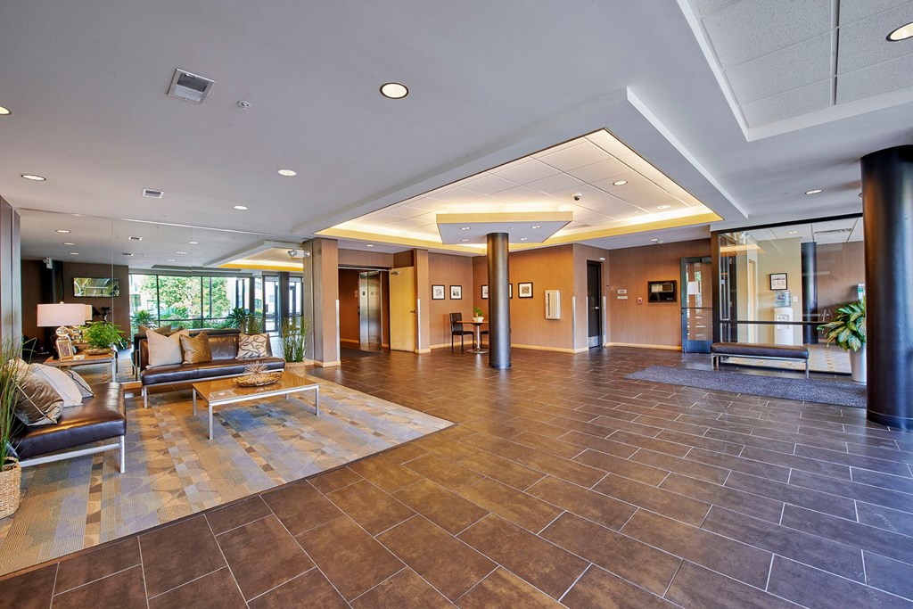 A spacious lobby with brown leather couches.