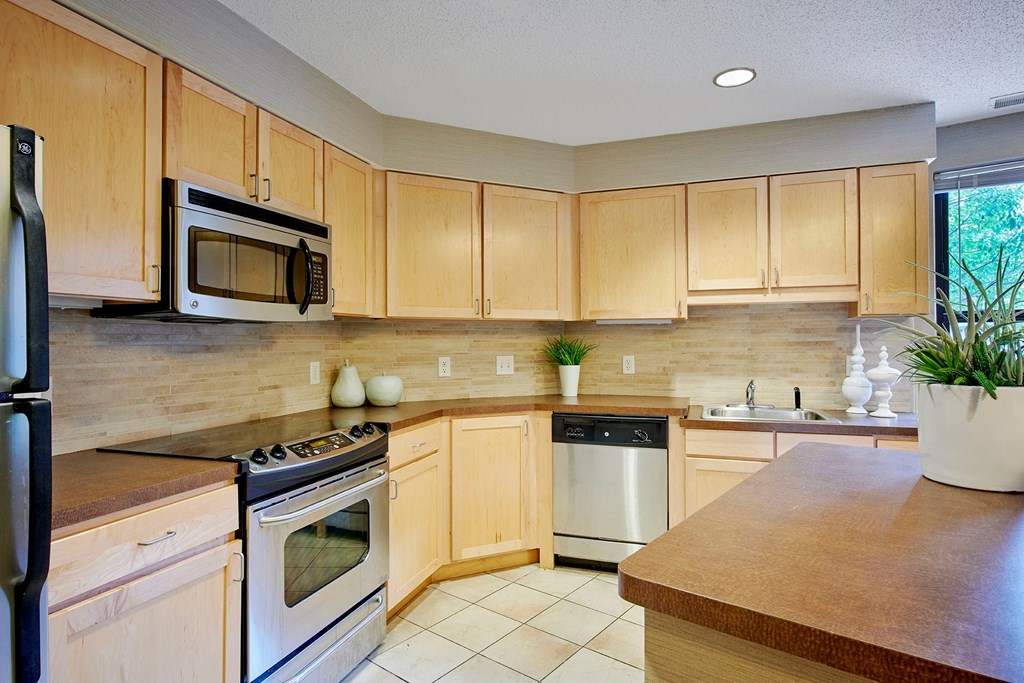 A kitchen with wooden cabinets and a stove top oven.