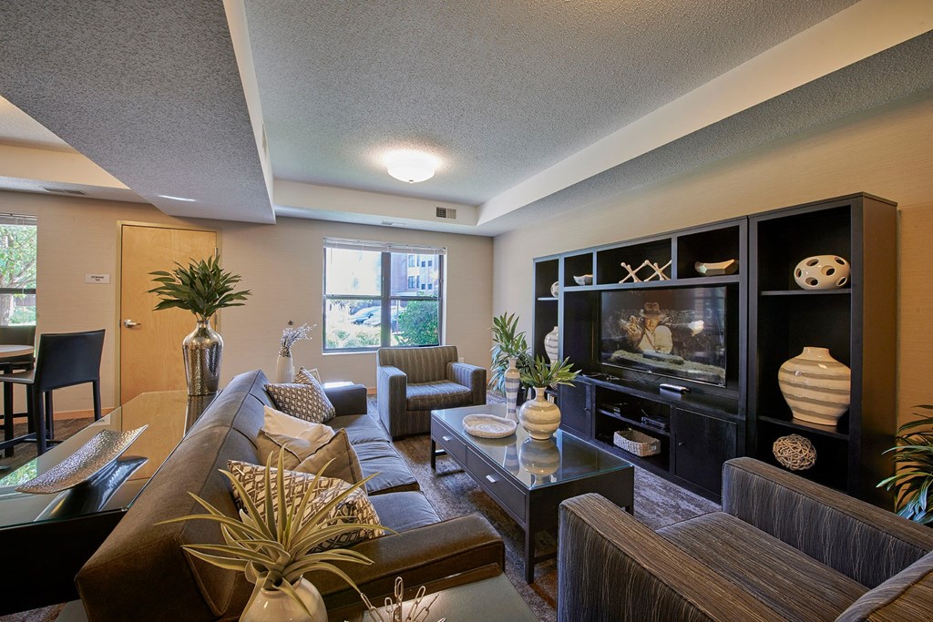 A living room with a brown couch, chairs, and a coffee table.