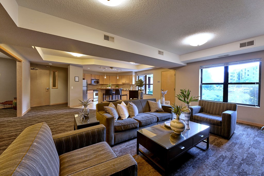 A living room with a brown couch, a coffee table, and chairs.