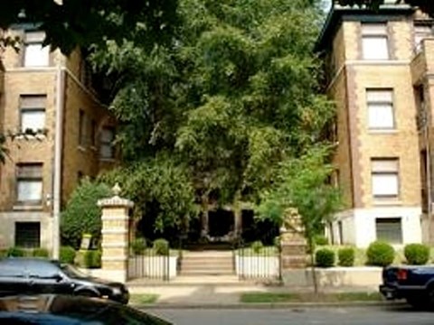 A black car is parked in front of a house.