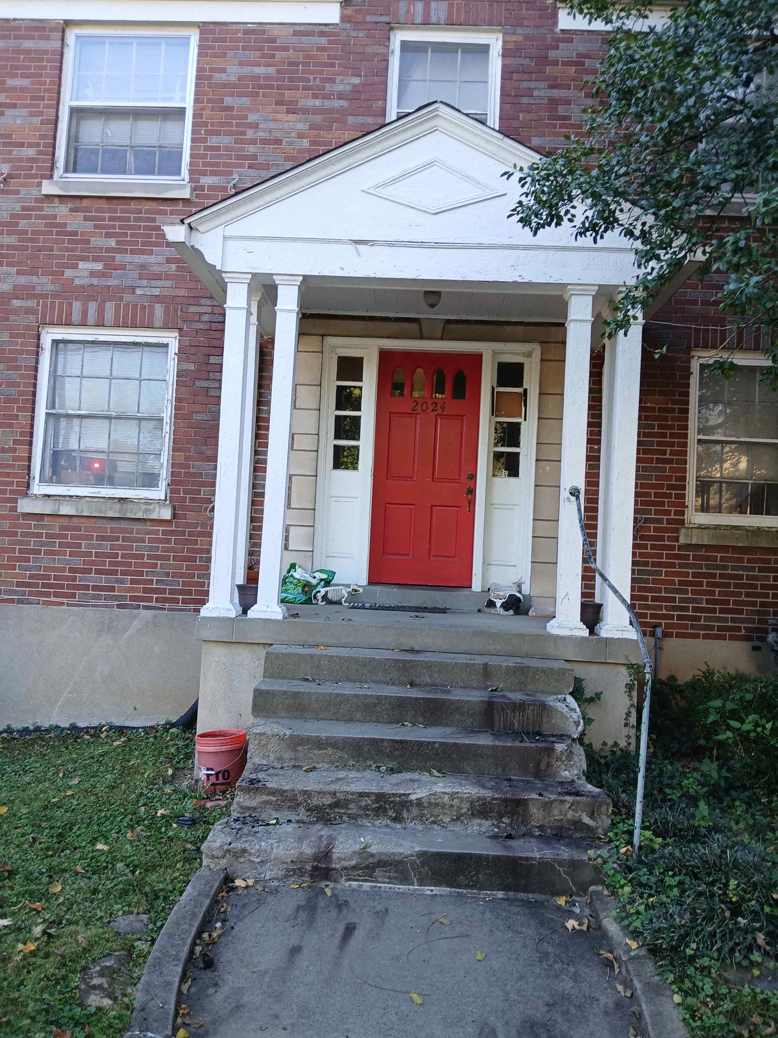 a brick house with a red door and steps