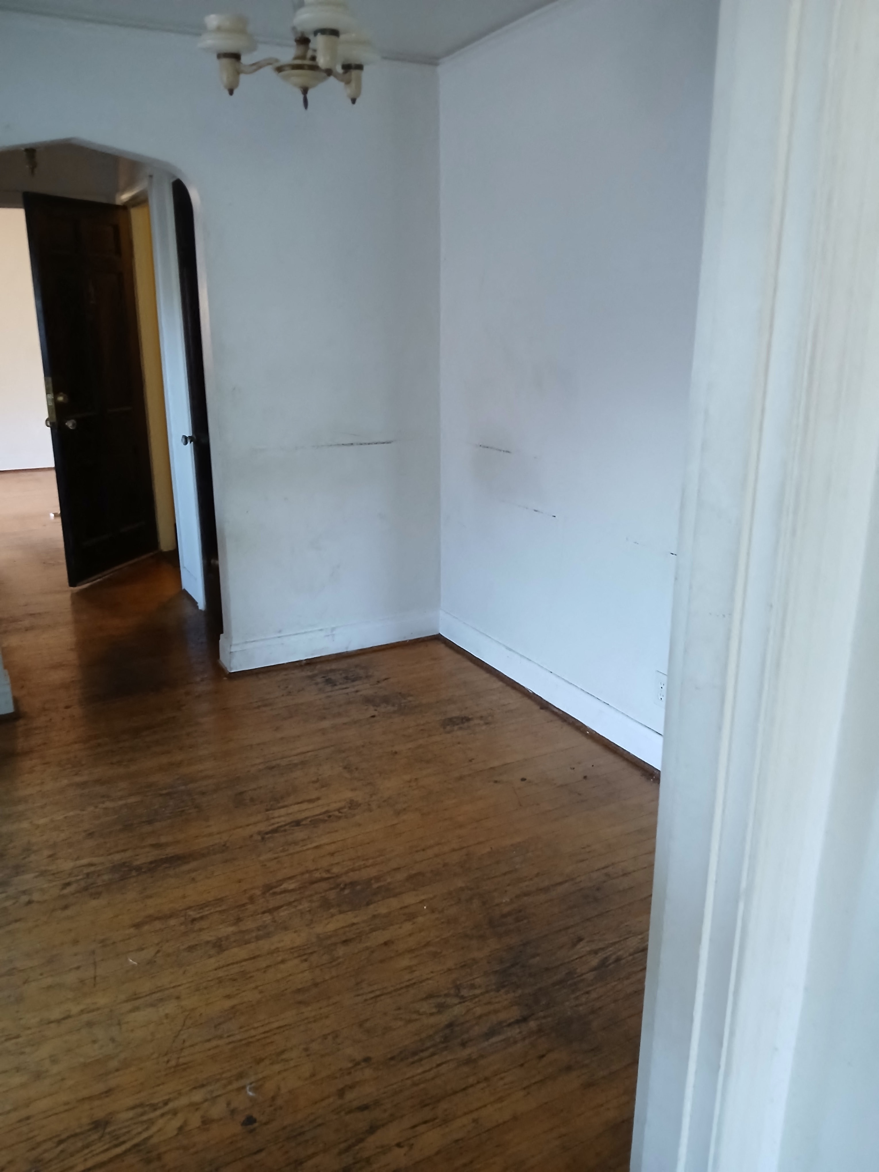 an empty room with white walls and a wooden floor